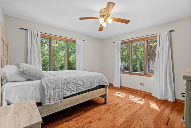 13302 Archer Ave, Lemont, IL 60439 - bedroom with multiple windows, light wood-type flooring, and a ceiling fan