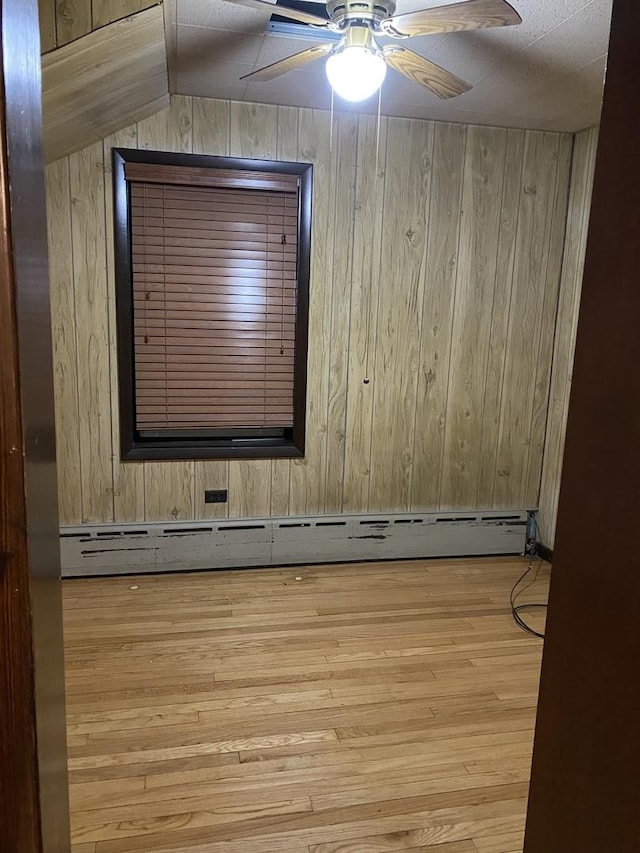 5015 S Talman Ave, Chicago, IL 60632 - spare room featuring wooden walls, wood finished floors, ceiling fan, and a baseboard radiator