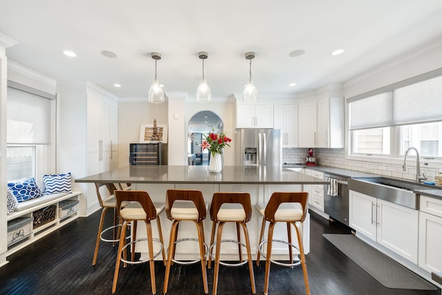 2012 W Charleston St, Chicago, IL 60647 - kitchen with stainless steel appliances, white cabinetry, crown molding, dark wood-type flooring, and decorative backsplash