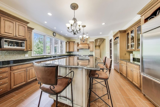 2940 Farner Ct, Riverwoods, IL 60015 - kitchen featuring built in appliances, a breakfast bar area, a chandelier, a kitchen island, and backsplash
