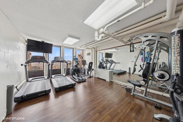 100 E Walton St Unit 40A, Chicago, IL 60611 - exercise room featuring wood finished floors, a textured ceiling, and concrete block wall