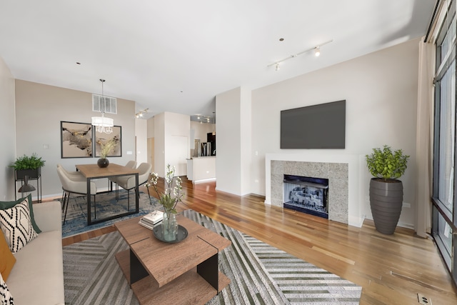 520 S State St Unit 1726, Chicago, IL 60605 - living area featuring light wood finished floors, a chandelier, a fireplace, and rail lighting