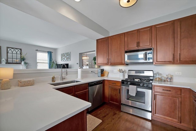 1854 Westridge Pl, Aurora, IL 60504 - kitchen featuring appliances with stainless steel finishes, light countertops, dark wood-style floors, brown cabinetry, and a peninsula
