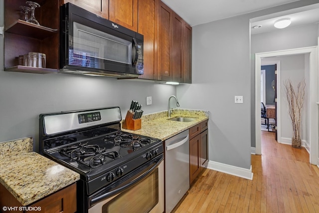 4850 N Oakley Ave Unit 1R, Chicago, IL 60625 - kitchen featuring appliances with stainless steel finishes, light wood-style floors, light stone counters, open shelves, and brown cabinets