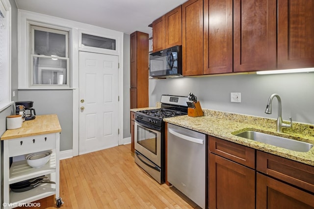 4850 N Oakley Ave Unit 1R, Chicago, IL 60625 - kitchen with appliances with stainless steel finishes, light wood-type flooring, and light stone counters