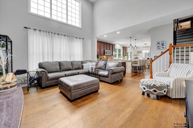 1880 Crofton Dr, Algonquin, IL 60102 - living area featuring light wood-style flooring, a towering ceiling, stairs, and a chandelier