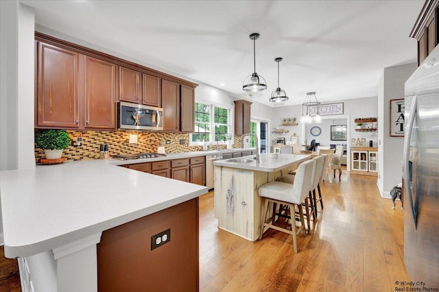 1880 Crofton Dr, Algonquin, IL 60102 - kitchen with stainless steel appliances, a breakfast bar area, light countertops, and light wood-style floors