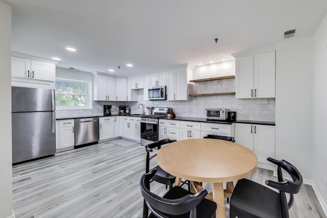 110 S Evergreen Ave Unit 4Cs, Arlington Heights, IL 60005 - kitchen featuring appliances with stainless steel finishes, dark countertops, light wood-style flooring, backsplash, and recessed lighting