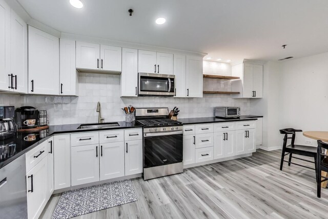 110 S Evergreen Ave Unit 4Cs, Arlington Heights, IL 60005 - kitchen with appliances with stainless steel finishes, open shelves, light wood-type flooring, white cabinetry, and backsplash