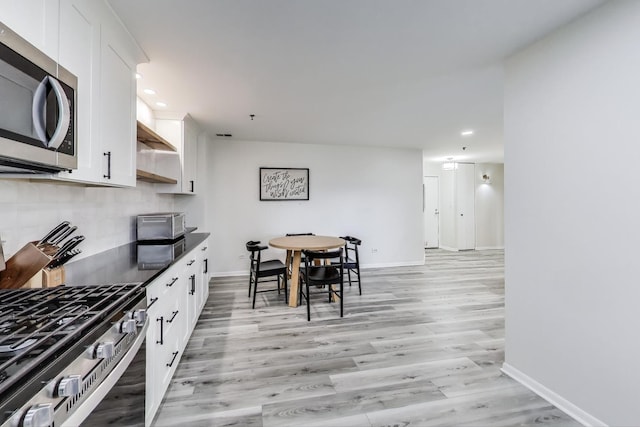 110 S Evergreen Ave Unit 4Cs, Arlington Heights, IL 60005 - kitchen featuring appliances with stainless steel finishes, open shelves, light wood-style flooring, recessed lighting, and dark countertops