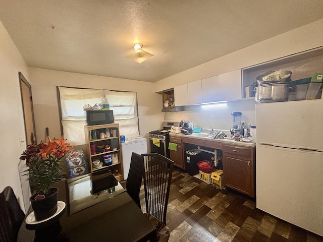 328 W Harrison St, Belvidere, IL 61008 - kitchen with freestanding refrigerator, black microwave, gas stove, refrigerator, and a desk