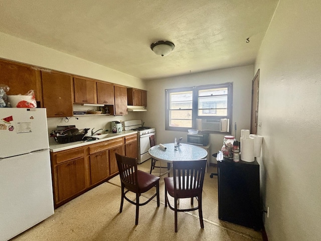328 W Harrison St, Belvidere, IL 61008 - kitchen with white appliances, brown cabinets, light countertops, and under cabinet range hood