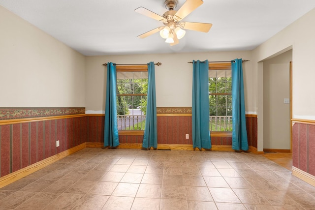 7204 Warblers Way, Roscoe, IL 61073 - unfurnished room with healthy amount of natural light, a wainscoted wall, and a ceiling fan