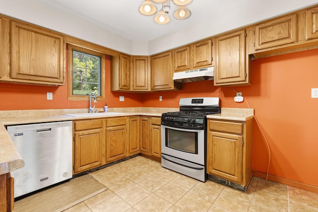 7204 Warblers Way, Roscoe, IL 61073 - kitchen with stainless steel appliances, under cabinet range hood, light countertops, brown cabinetry, and light tile patterned flooring
