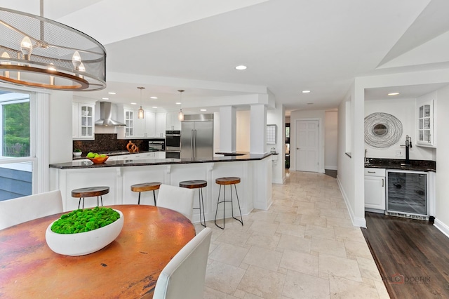 1819 Farm Rd, Lake Forest, IL 60045 - kitchen with beverage cooler, wall chimney exhaust hood, appliances with stainless steel finishes, dark countertops, and white cabinetry