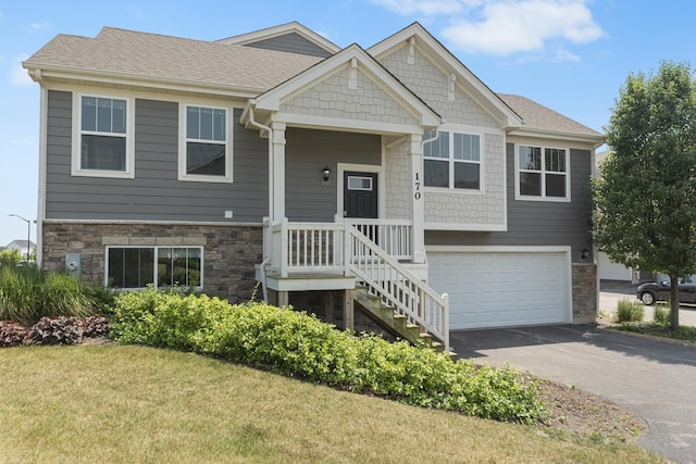 170 Goldenrod Dr, Elgin, IL 60124 - view of front of home with driveway, stone siding, an attached garage, a front yard, and a shingled roof