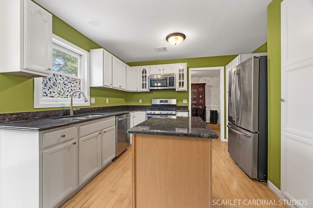 3100 Compton Rd, Aurora, IL 60504 - kitchen featuring stainless steel appliances, a kitchen island, white cabinetry, glass insert cabinets, and dark stone countertops