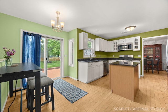 3100 Compton Rd, Aurora, IL 60504 - kitchen featuring stainless steel appliances, a chandelier, white cabinetry, glass insert cabinets, and dark countertops