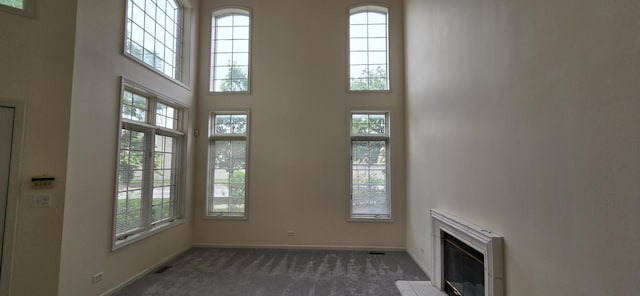 1410 49th Ct, Western Springs, IL 60558 - unfurnished living room with carpet flooring, plenty of natural light, a towering ceiling, and a glass covered fireplace