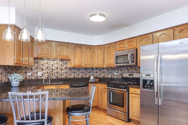 5135 W 113th Pl, Alsip, IL 60803 - kitchen with appliances with stainless steel finishes, a peninsula, brown cabinets, tasteful backsplash, and a breakfast bar area