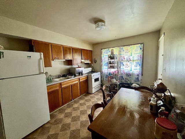 1027 Strawberry Ln, Belvidere, IL 61008 - kitchen with white appliances, brown cabinetry, and under cabinet range hood