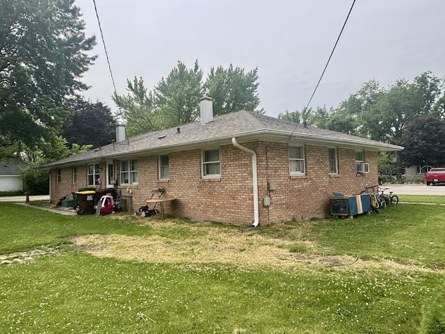 1027 Strawberry Ln, Belvidere, IL 61008 - rear view of property featuring a yard, brick siding, and a chimney