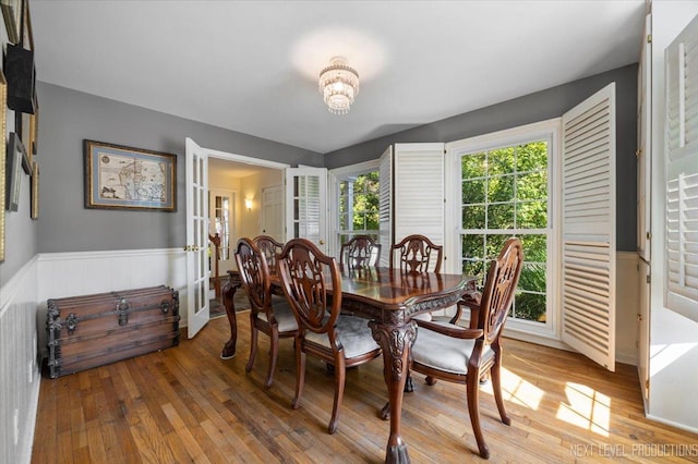 932 S Batavia Ave, Geneva, IL 60134 - dining area with light wood-type flooring, a wainscoted wall, a chandelier, and french doors