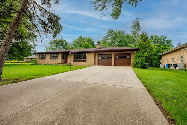 706 Heatherhill Rd, Bloomington, IL 61704 - single story home with an attached garage, a chimney, a front lawn, driveway, and brick siding