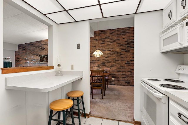 1420 Woodbridge Rd Unit 3C, Joliet, IL 60436 - kitchen featuring white appliances, a breakfast bar, brick wall, light countertops, and light colored carpet