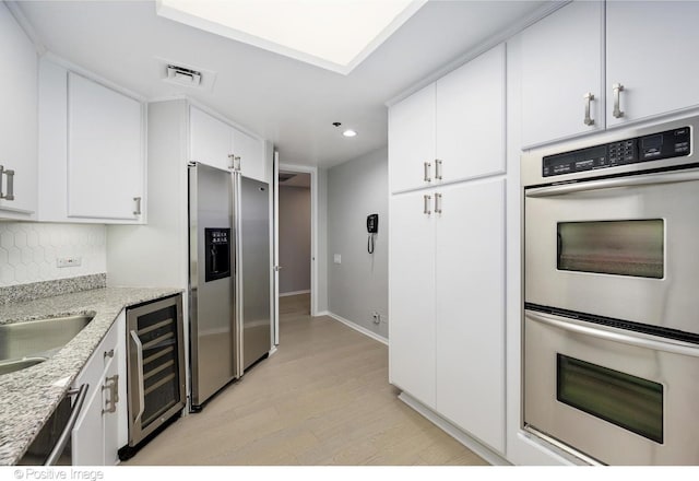 950 N Michigan Ave Unit 2901, Chicago, IL 60611 - kitchen with wine cooler, stainless steel appliances, light wood-type flooring, recessed lighting, and white cabinets