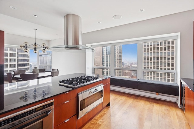 800 N Michigan Ave Unit 3103, Chicago, IL 60611 - kitchen with stainless steel appliances, a baseboard heating unit, light wood-style flooring, a chandelier, and brown cabinets