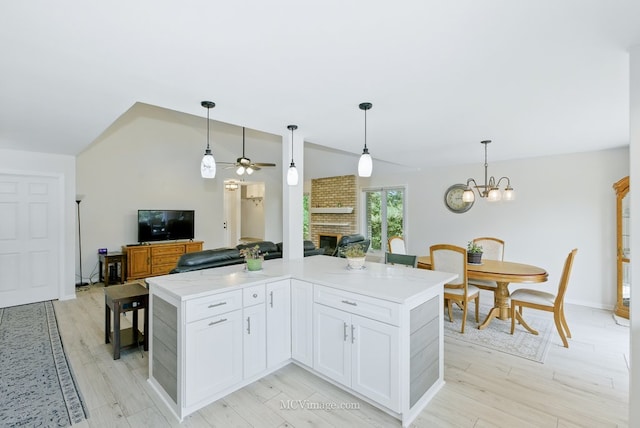 10935 Barbs Way, Orland Park, IL 60467 - kitchen featuring a fireplace, ceiling fan, vaulted ceiling, open floor plan, and white cabinetry