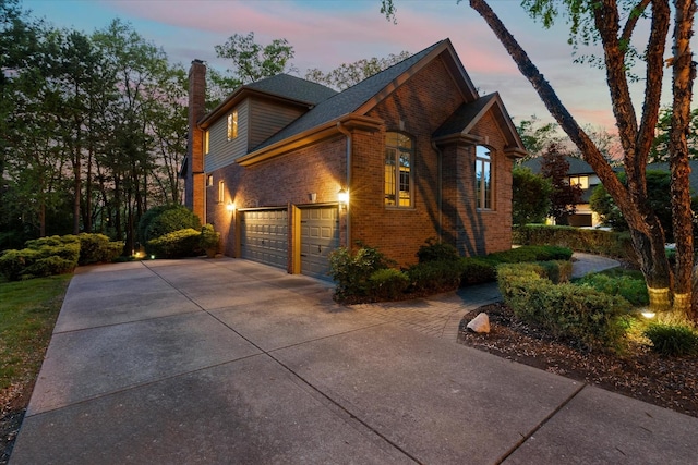 1396 Notre Dame Dr, Lemont, IL 60439 - property exterior at dusk with a chimney, concrete driveway, and brick siding