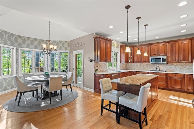 1396 Notre Dame Dr, Lemont, IL 60439 - kitchen featuring stainless steel appliances, a chandelier, light wood-type flooring, tasteful backsplash, and brown cabinets