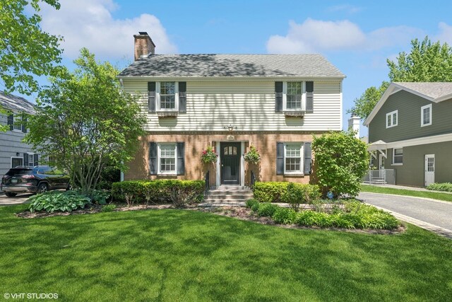 2236 Birchwood Ave, Wilmette, IL 60091 - view of front of house with a chimney, a front yard, and brick siding