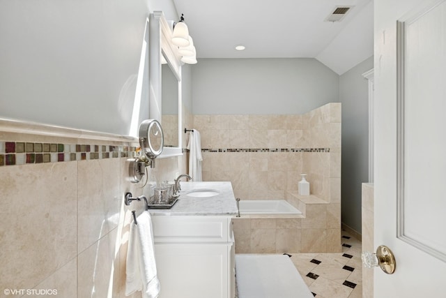 2236 Birchwood Ave, Wilmette, IL 60091 - full bathroom featuring a garden tub, vanity, tile walls, lofted ceiling, and tile patterned flooring