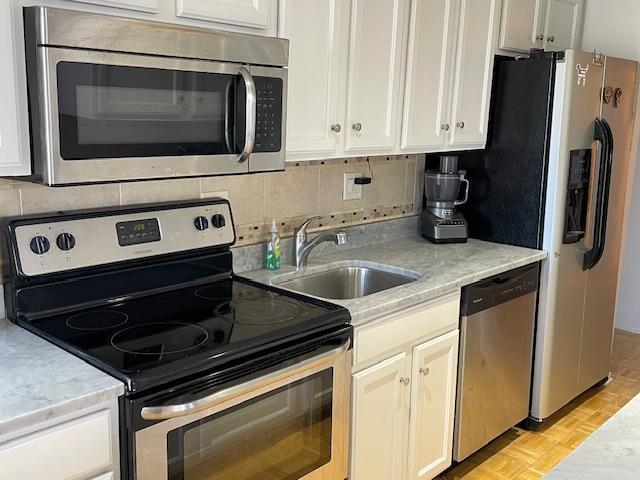 345 N Canal St Unit 1204, Chicago, IL 60606 - kitchen featuring stainless steel appliances, white cabinetry, light stone countertops, and backsplash