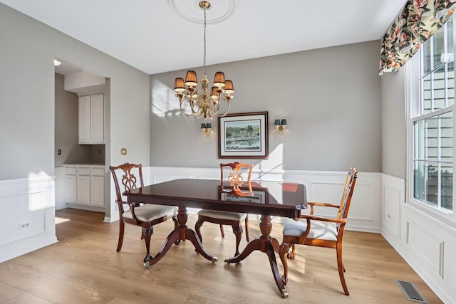 1128 Teasel Ln, Naperville, IL 60564 - dining room with a wainscoted wall, light wood-type flooring, a chandelier, and a decorative wall