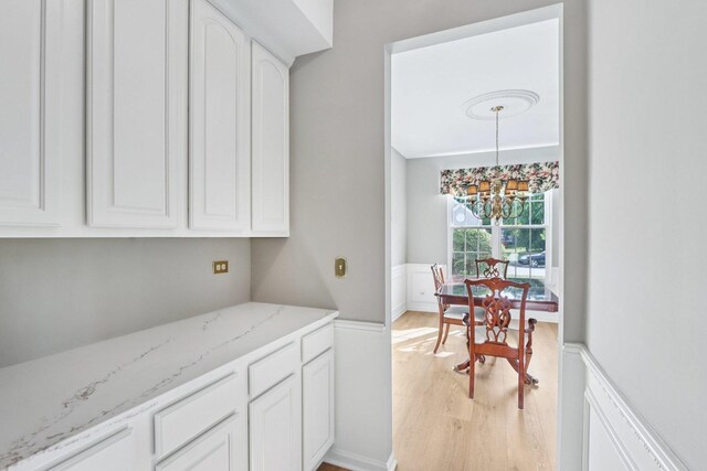 1128 Teasel Ln, Naperville, IL 60564 - kitchen with a chandelier, light wood-style flooring, white cabinets, light stone countertops, and pendant lighting