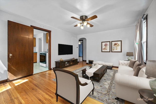 1165 Morton Ave, Elgin, IL 60120 - living room with arched walkways, a ceiling fan, and light wood-style floors
