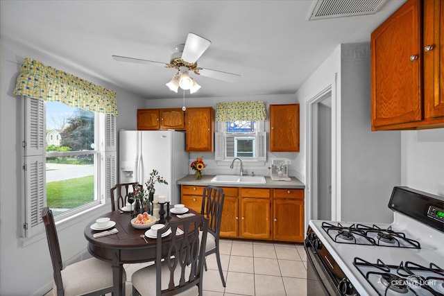 1165 Morton Ave, Elgin, IL 60120 - kitchen featuring white appliances, a ceiling fan, light countertops, and brown cabinets