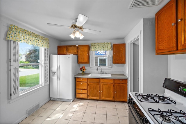 1165 Morton Ave, Elgin, IL 60120 - kitchen with white appliances, plenty of natural light, and brown cabinets