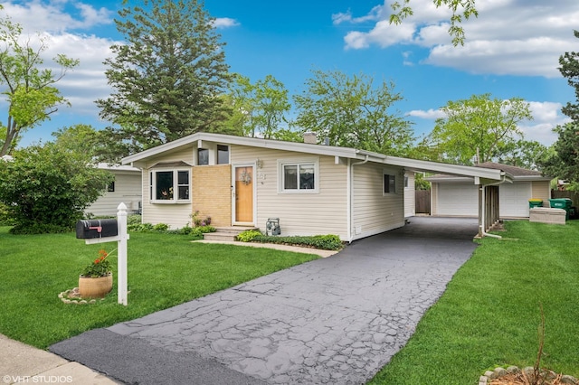 25 W Jeffery Ave, Wheeling, IL 60090 - mid-century modern home with a carport, a front yard, and driveway