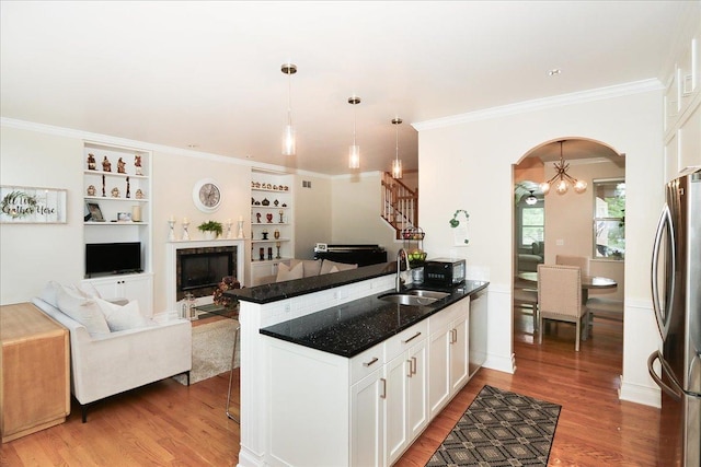 768 W St Johns Pl, Addison, IL 60101 - kitchen with freestanding refrigerator, light wood-style flooring, arched walkways, a fireplace, and a peninsula