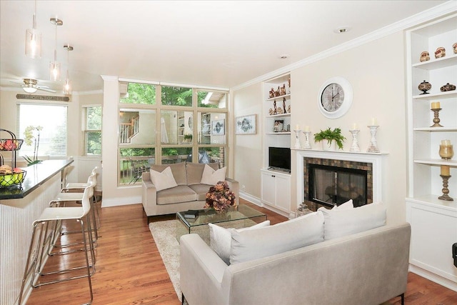 768 W St Johns Pl, Addison, IL 60101 - living area with ornamental molding, built in shelves, light wood-type flooring, a fireplace, and ceiling fan
