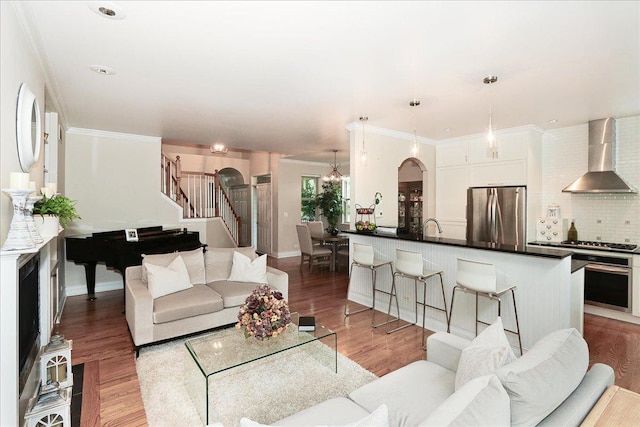 768 W St Johns Pl, Addison, IL 60101 - living room with light wood-style flooring, stairway, a chandelier, arched walkways, and ornamental molding