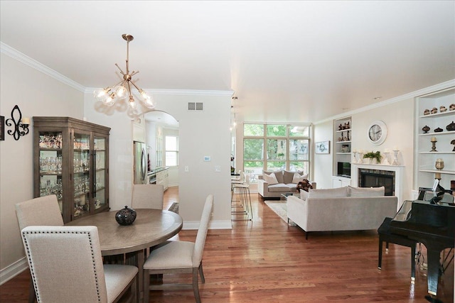 768 W St Johns Pl, Addison, IL 60101 - dining area featuring built in features, ornamental molding, arched walkways, wood finished floors, and a fireplace
