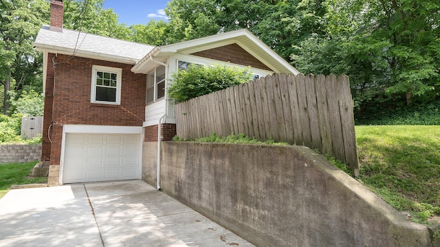 931 C St, Rockford, IL 61107 - view of front of property featuring brick siding, a chimney, driveway, an attached garage, and roof with shingles