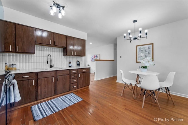 1422 Ridgeway St, Round Lake Beach, IL 60073 - kitchen with a chandelier, backsplash, light countertops, and wood finished floors