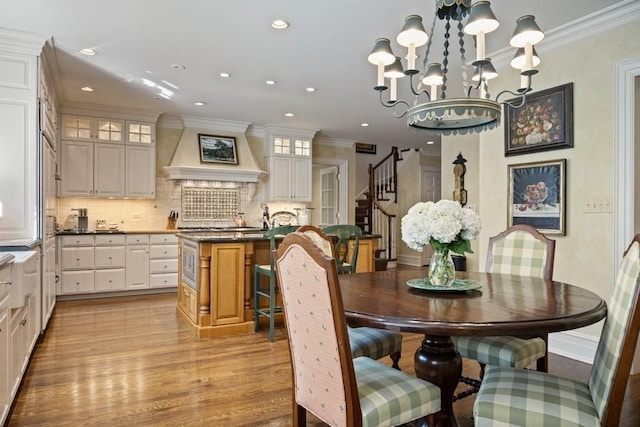 5 Woodley Rd, Winnetka, IL 60093 - dining room featuring a chandelier, light wood-style flooring, recessed lighting, crown molding, and stairway